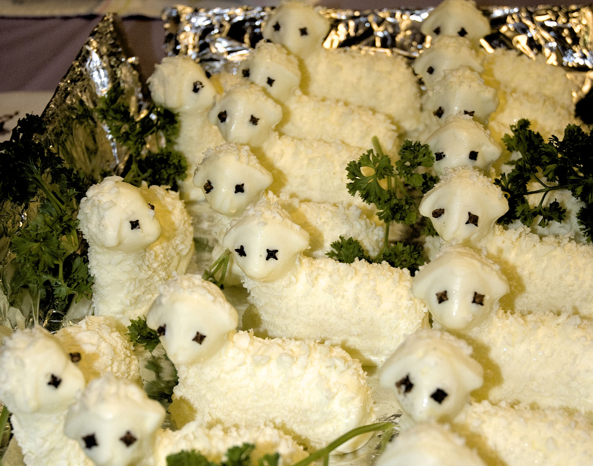 Foil lined container holding butter lambs with clove eyes.