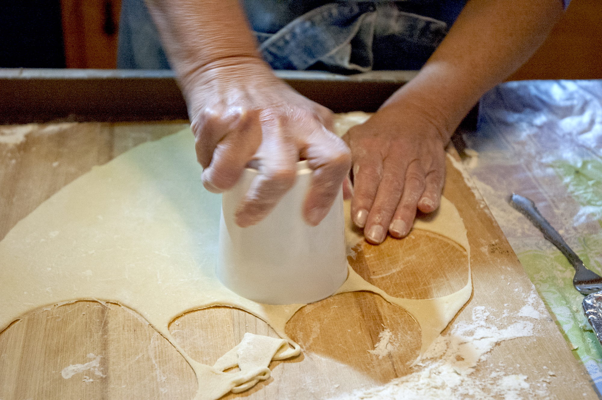 Carol cutting circle of dough.