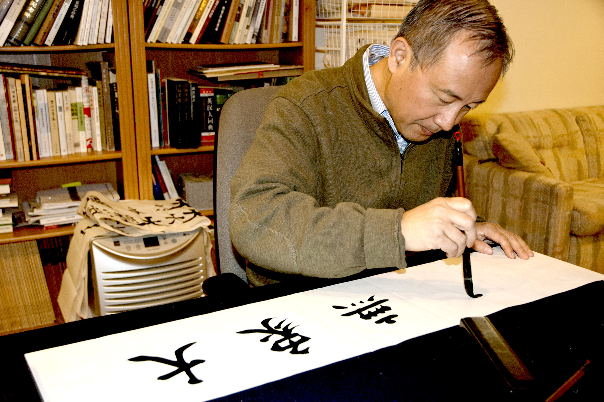 Qianshen Bai demonstrating calligraphy brush stroke.
