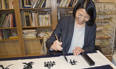 Apprentice Mei Hung using calligraphy brush.