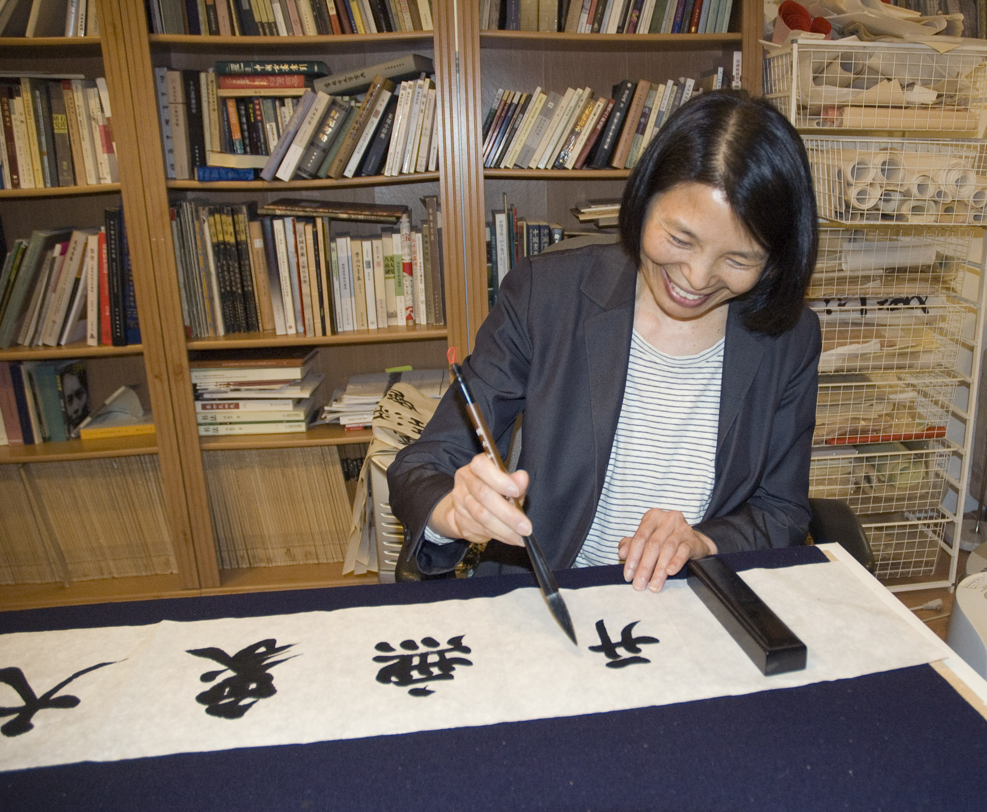 Apprentice Mei Hung using calligraphy brush.