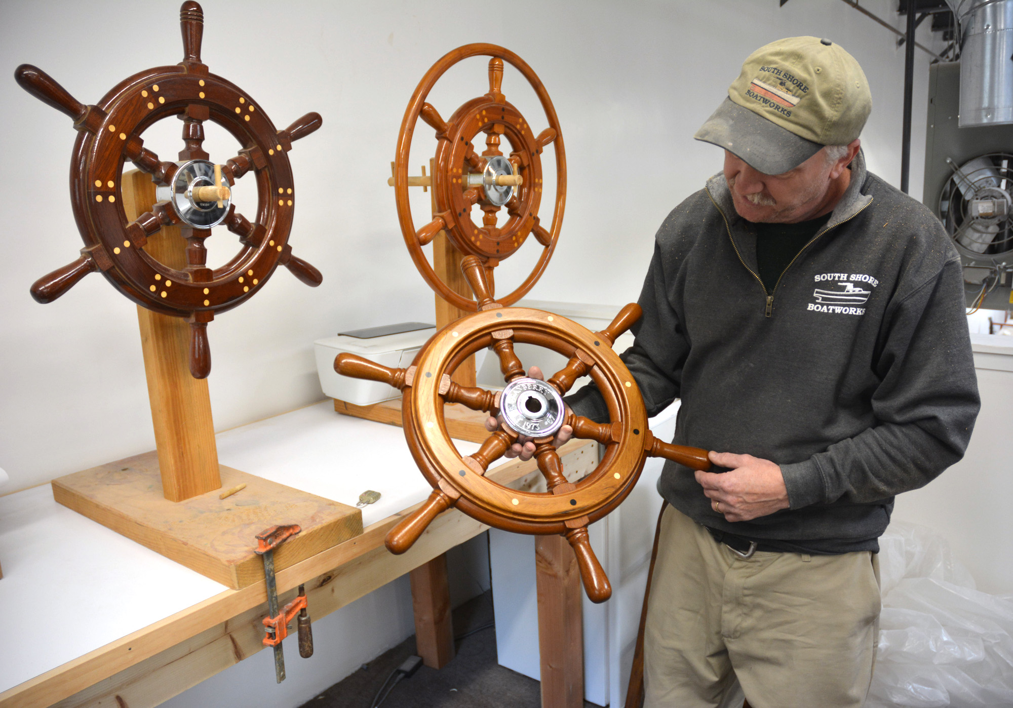 Bob Fuller holding one of his ship’s wheels.