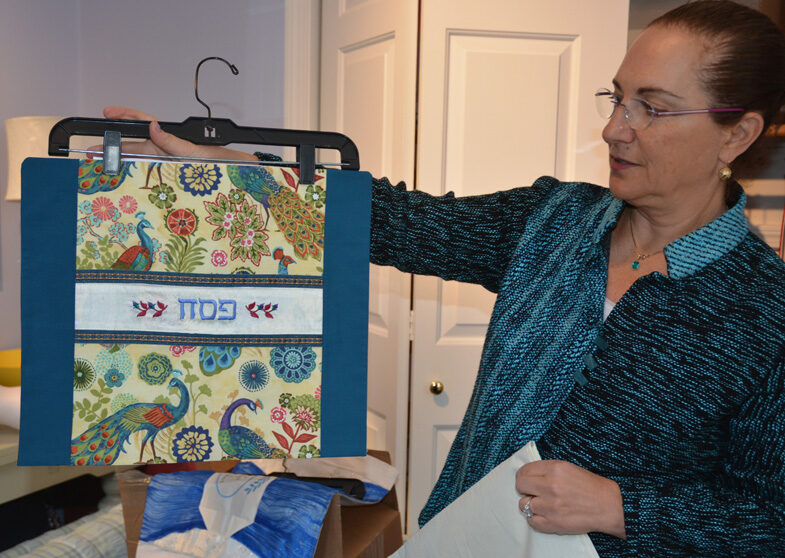 Amy holding up afikomen bag embroidered with Hebrew letters for Pesach.