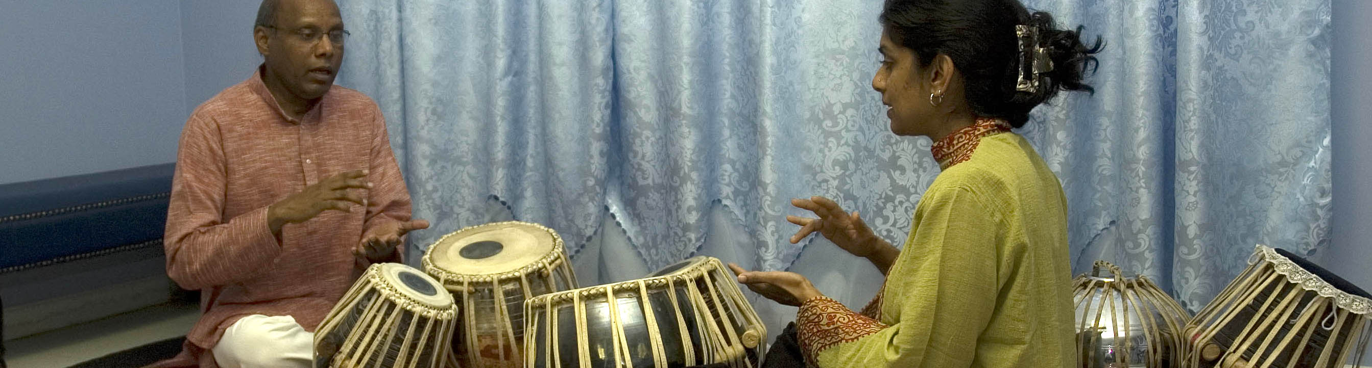 Chris Pereji playing tabla drums with apprentice Nisha Purushotham. Photo by Maggie Holtzberg.