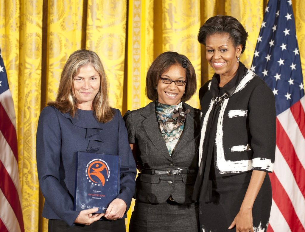 First Lady Michelle Obama awarding the President’s Committee on the Arts and the Humanities to representatives from The Care Center.