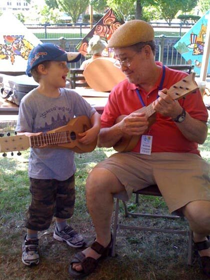 William Cumpiano playing cuatro with young festival-goer, 2011.