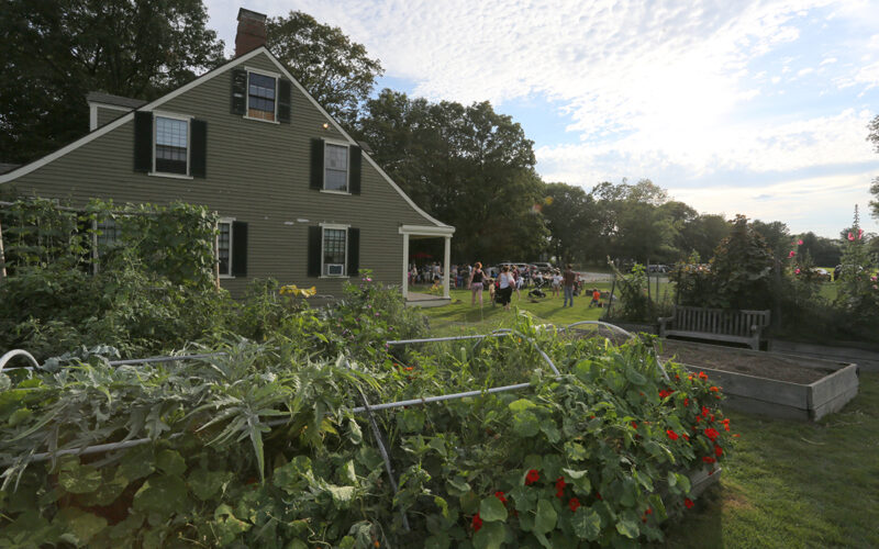 Gardens and people gathered on front lawn of the 1835 Farm Manager's Cottage at Gore Place Society