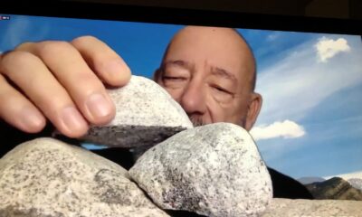 Close up of a bald man stacking rocks