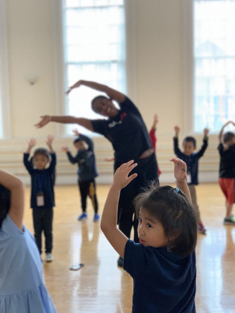 Young girl in a dance class looks over her left shoulder.