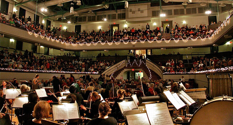 Orchestra on a stage playing for a full house.