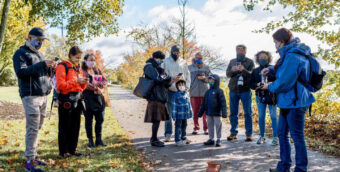 masked festival goers standing on a trail as part of the Fabric Arts Festival in Fall River