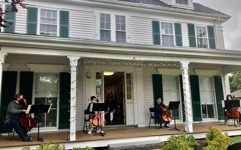 Cellists performing on the front porch
