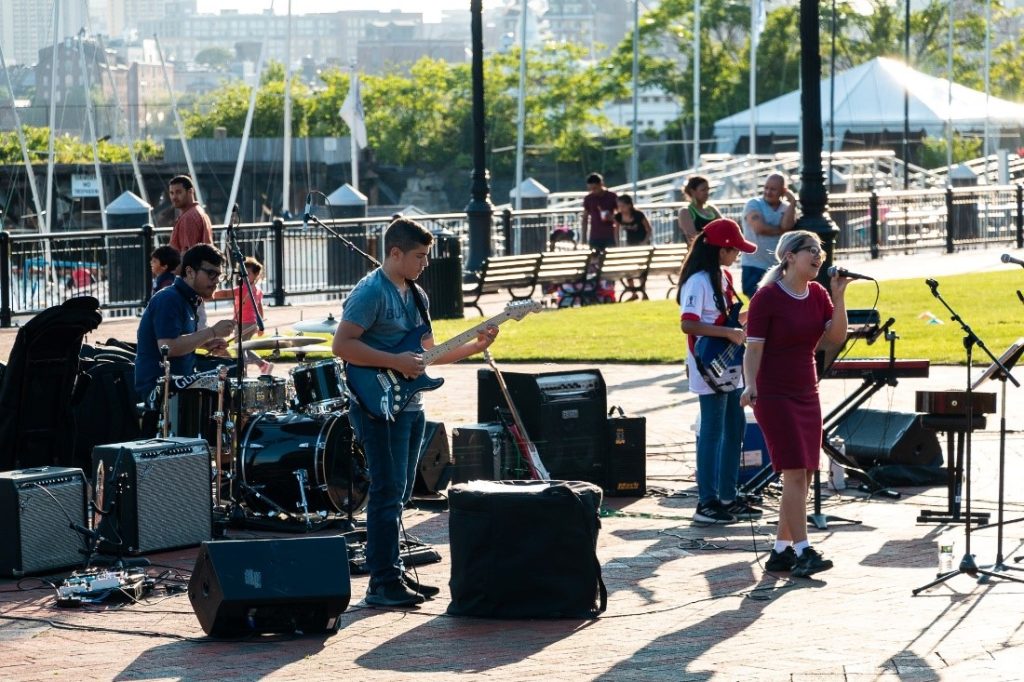 a 4-person band performs outside near Boston Harbor