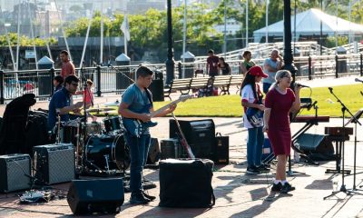 musicians perform outside near Boston Harbor