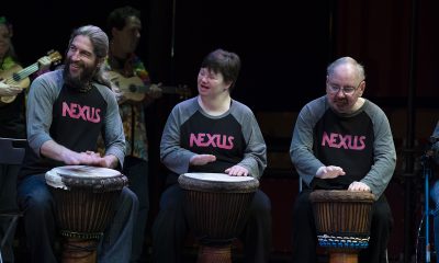 photo of 3 people sitting on a stage with African-style drums between their knees