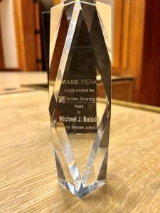photo of a crystal award object with the inscription MassOpera proudly presents the Action Bearing Award to Michael J. Bobbitt