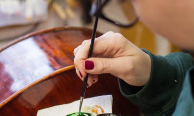 photo of person doing touch up painting on a stringed instrument