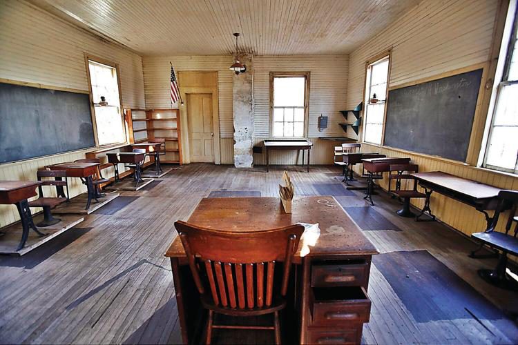 Antique desks and chairs along the walls of the historic North Schoolhouse