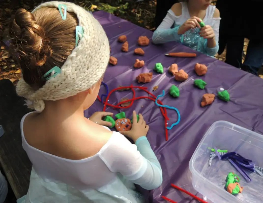 photo of children doing a craft project with clay and string