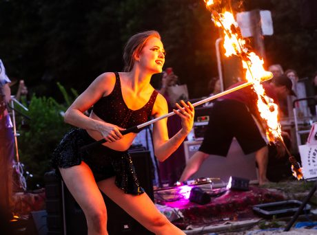 photo of a woman twirling fire on a beach at dusk