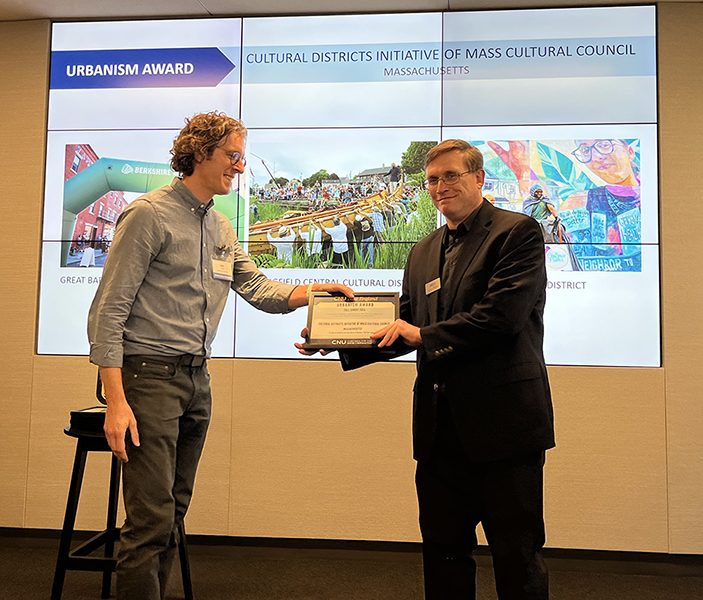 photo of David Slatery receiving a certificate from a CNU New England board member