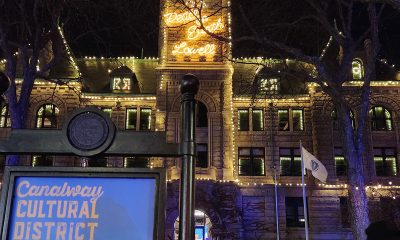 white lights outline Lowell's City Hall building and spell out the words Peace on Earth Lowell