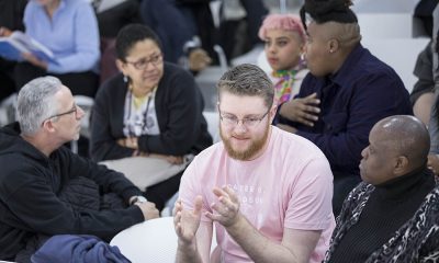 photo of a diverse range of people sitting in different small groups talking to one another