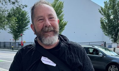 photo of a smiling middle aged man wearing all black.