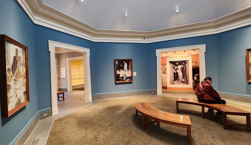 Person sitting on a bench in a gallery at the Norman Rockwell Museum