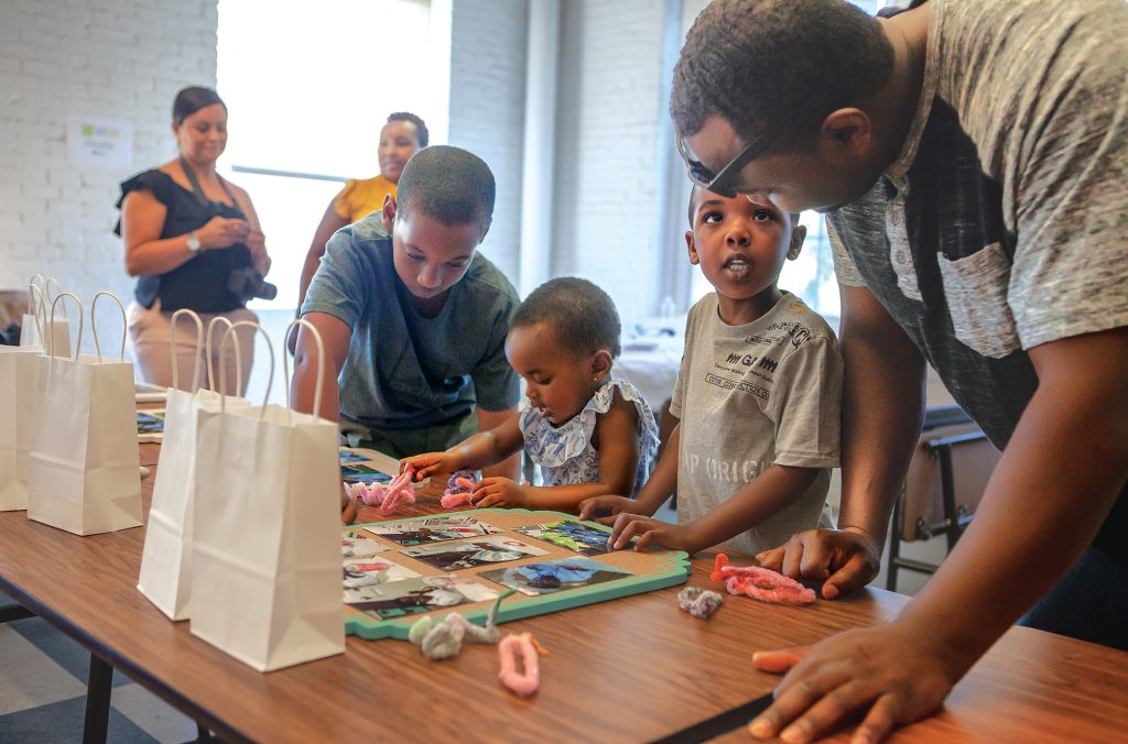 photo of young people and their care givers engaged in an craft project during a community STEAM event.