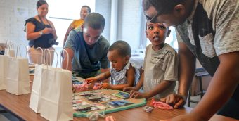 photo of young people and their care givers engaged in an craft project during a community STEAM event.