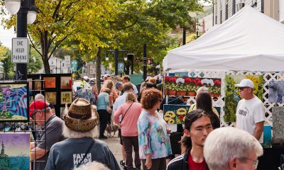 photo of a busy street fair with artists selling their paintings and people milling around.