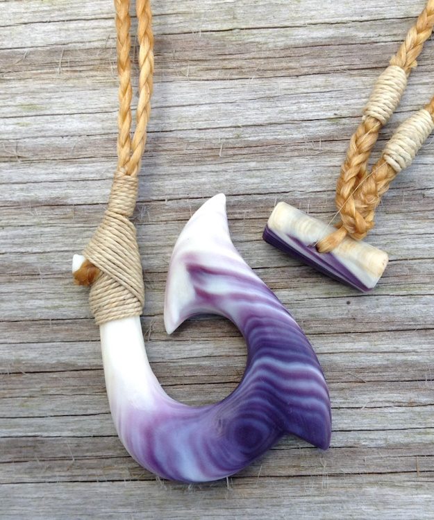 photo of two differently shaped pendants carved out of cream and purple Quahog shells.