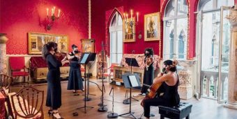 photo of a string quartet giving performance in an ornate room with red walls at the Isabella Stewart Gardner Museum.