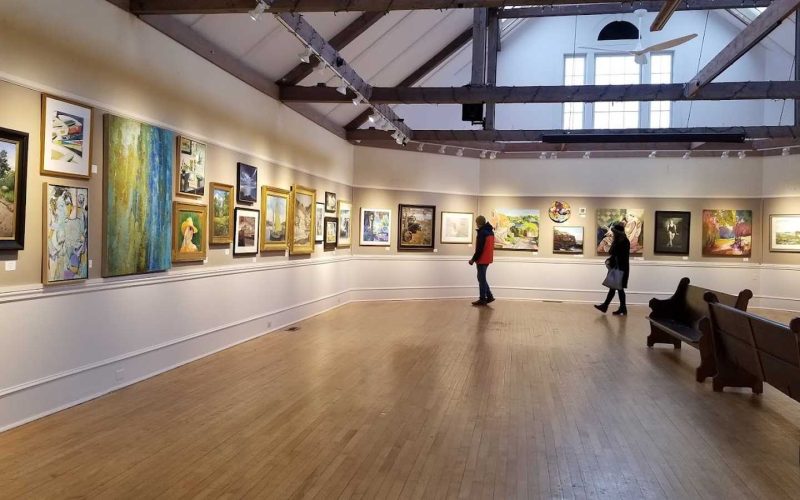 People looking at art in the gallery at the Rockport Art Association  & Museum