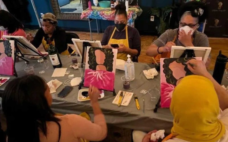 People seated at a table creating artwork at STEP Nation