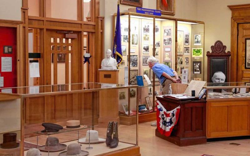 A person viewing an exhibit at the Calvin Coolidge Presidential Library and Museum at Forbes Library