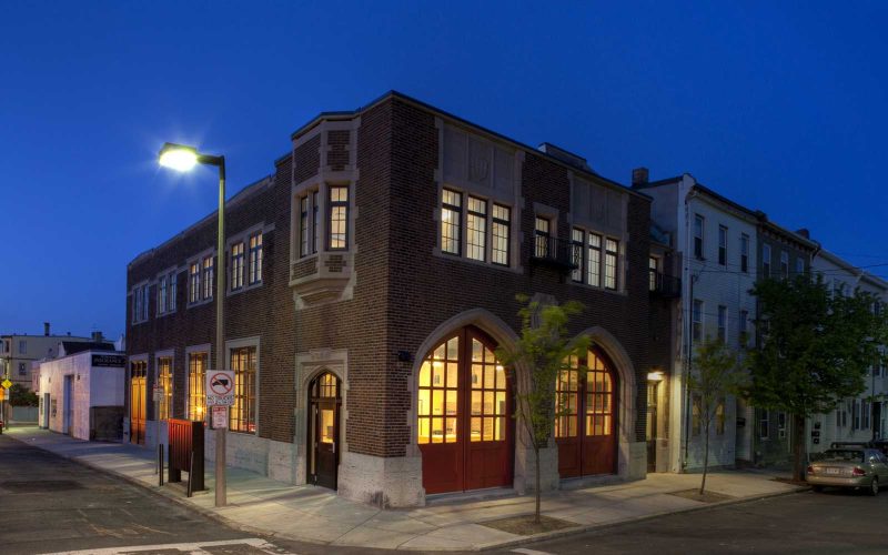 View of the brick exterior of Zumix from an opposing street corner at night