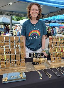 photo of an artist selling her jewelry at an arts festival.