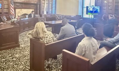 photo of a committee seated in a hearing room accepting testimony.