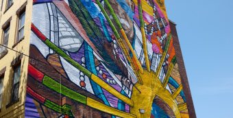 photo of a brilliantly colored mural covering the entire side of a 5 story building