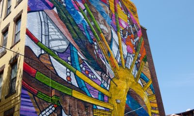 photo of a brilliantly colored mural covering the entire side of a 5 story building