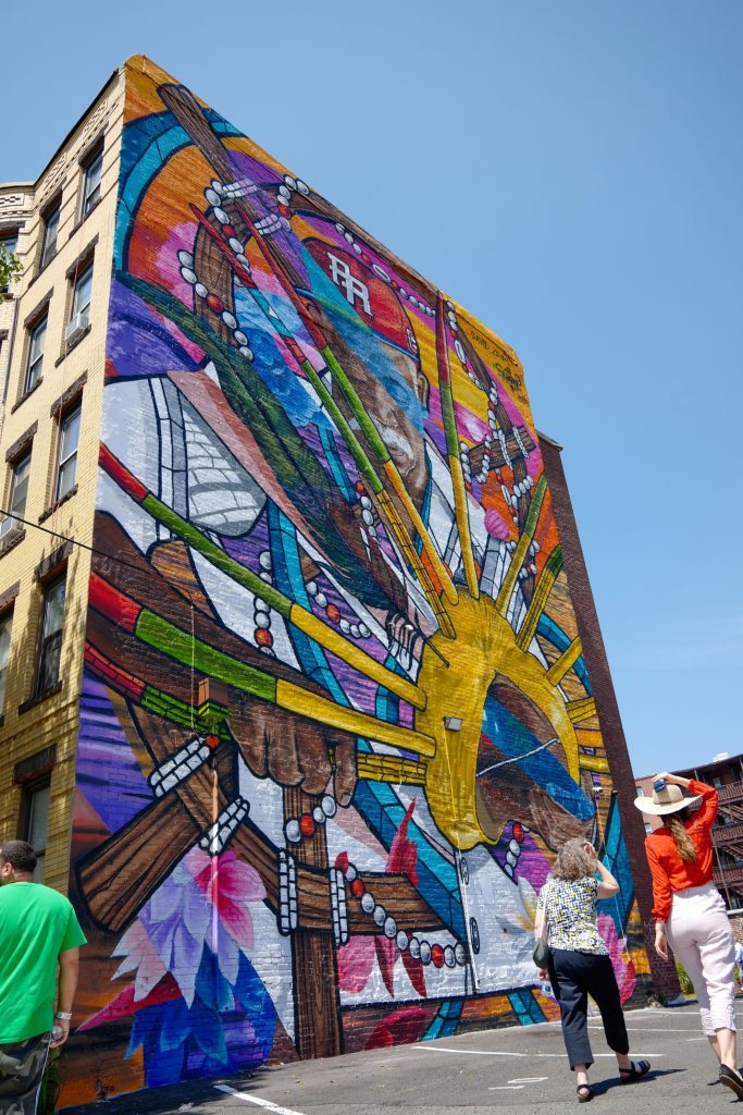 photo of a brilliantly colored mural covering the entire side of a 5 story building