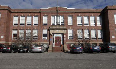 photo of a facade of an old brick two story school building.