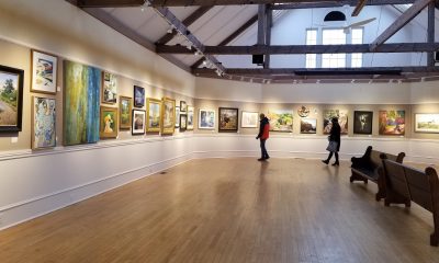 People viewing art hanging in a gallery.