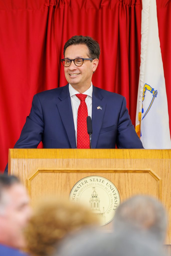 photo of Vinny deMacedo speaking at a podium.