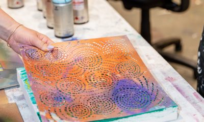 photo of an artist spray painting a stencil