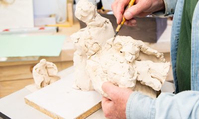 photo of an artist's hands working with clay.