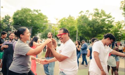photo of couples smiling and dancing on a warm day.