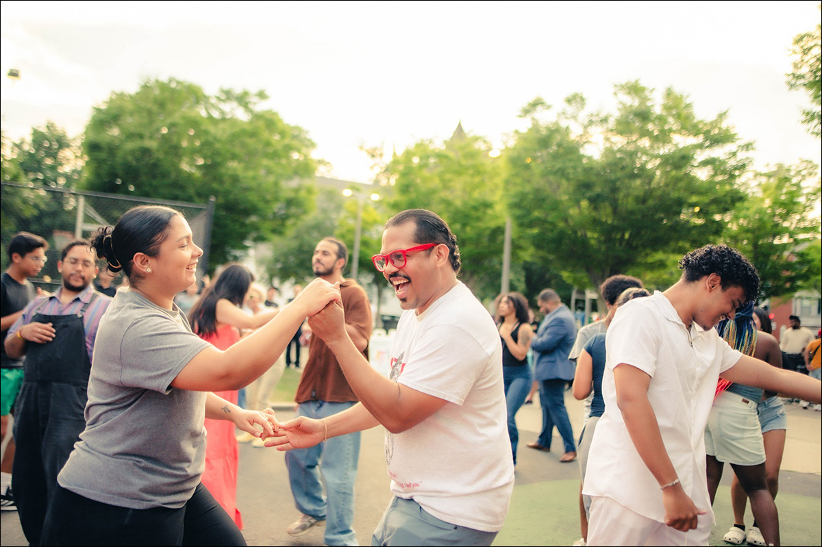 photo of couples smiling and dancing on a warm day.